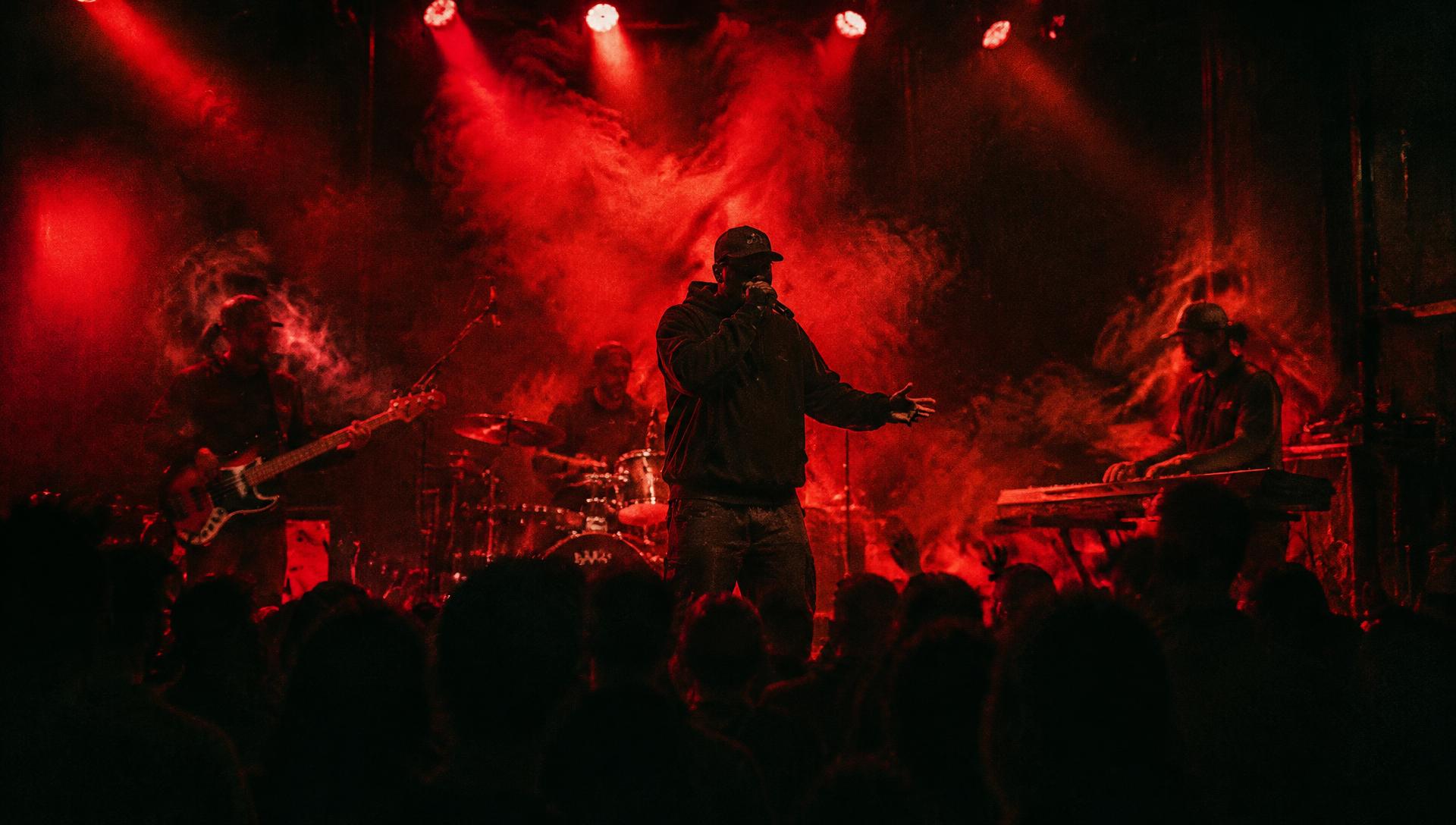 Live hip hop show with band under red lights